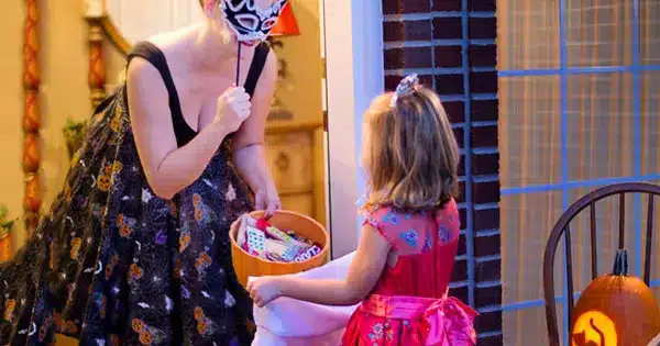 Woman surprising a girl with bucket full of candies