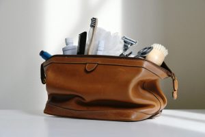 Leather travel toiletry bag packed with a toothbrush, toothpaste and razor