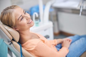 Smiling patient relaxing in a dental chair before a fluoride treatment