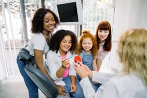 Family learning proper tooth brushing technique from dentist in dental clinic