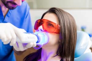 Patient receiving professional in-office teeth whitening treatment with protective glasses at Yonge Eglinton Dental in Toronto