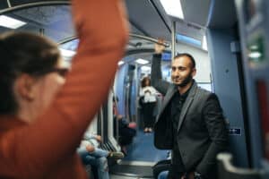 Man in business attire commuting by subway in Midtown Toronto, reflecting urban workday stress