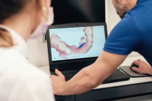 Dentist showing a digital teeth scan to a colleague in a modern dental clinic, demonstrating how advanced dental technology improves patient care at Yonge Eglinton Dental.